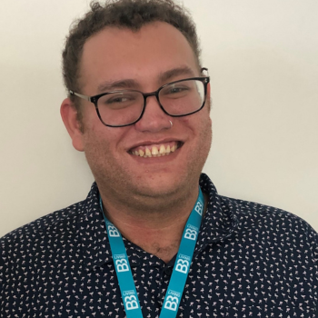 A smiling man wearing glasses and a B3Living lanyard around his neck