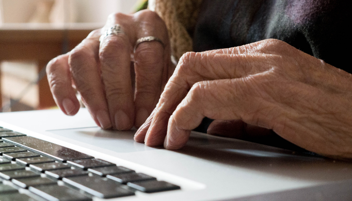 Senior person making housing application on laptop